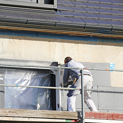 homme sur un echafaudage maison