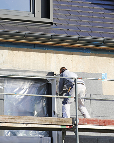 homme sur un echafaudage maison